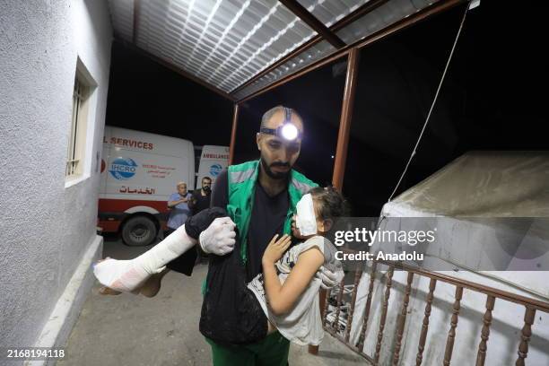 Staff carries an injured Palestinian girl at Al-Ahli Baptist Hospital following a fire broke out the Israeli army attack on the house of the Jarada...
