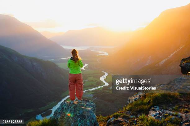 hiker admiring dramatic sunset time in the mountains with view of scenic valley - northern european descent stock pictures, royalty-free photos & images