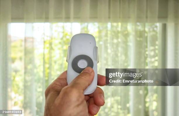 closing a shutter with remote control in my left hand. - motor eléctrico fotografías e imágenes de stock