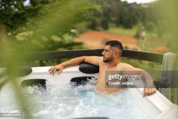 man enjoying outdoor hot tub - hot tub stock pictures, royalty-free photos & images
