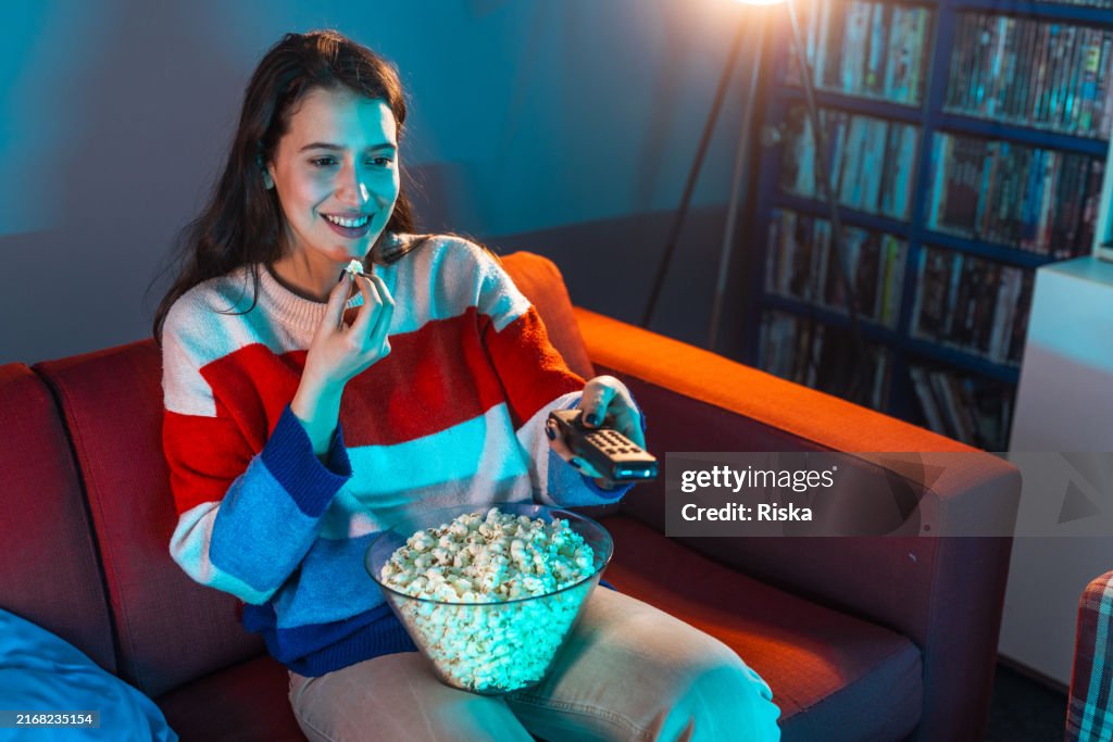 Woman enjoying a movie night at home with popcorn
