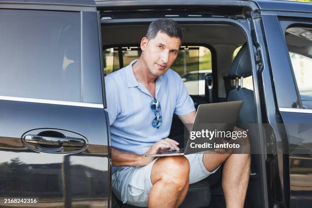 businessman sitting in car working on laptop. mobile office concept. - car interior stock pictures, royalty-free photos & images
