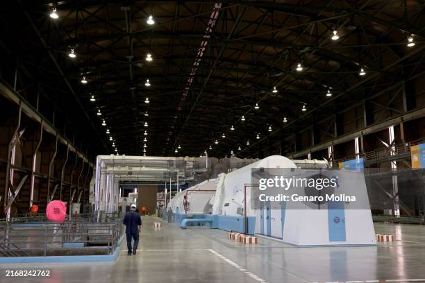 Employee walks past one of two turbine-generator units inside the turbine building at Diablo Canyon Nuclear Power Plant in San Luis Obispo on August...