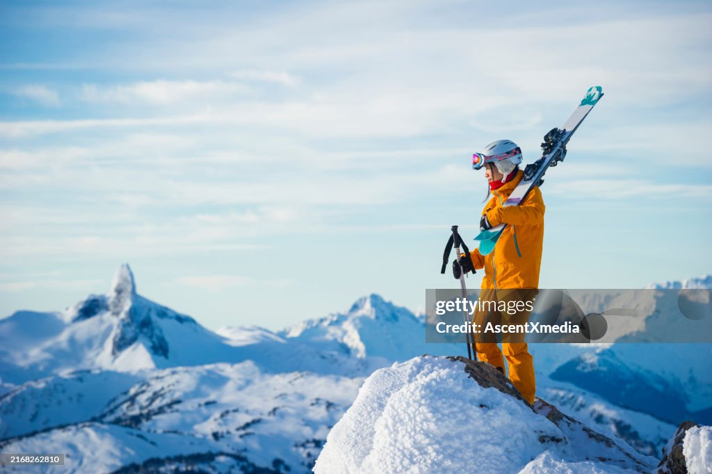 Portrait of young woman skier on mountain top