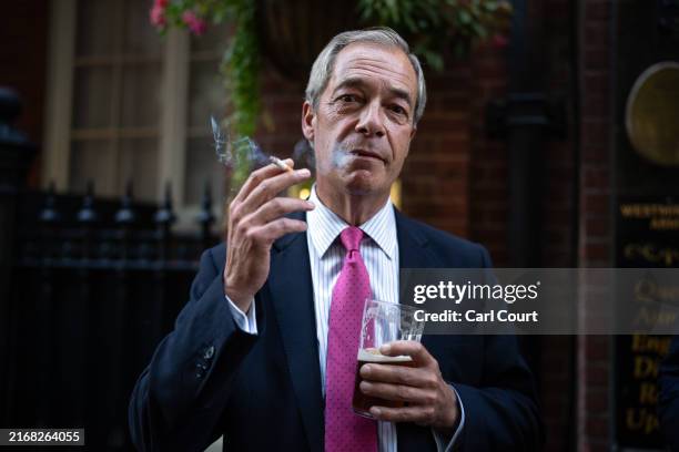 Reform UK leader Nigel Farage smokes a cigarette and drinks a pint of ale outside a pub on August 29, 2024 in London, England. The UK government is...