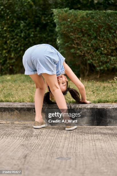 funny little girl bending on curb and looking at camera - curb stock pictures, royalty-free photos & images