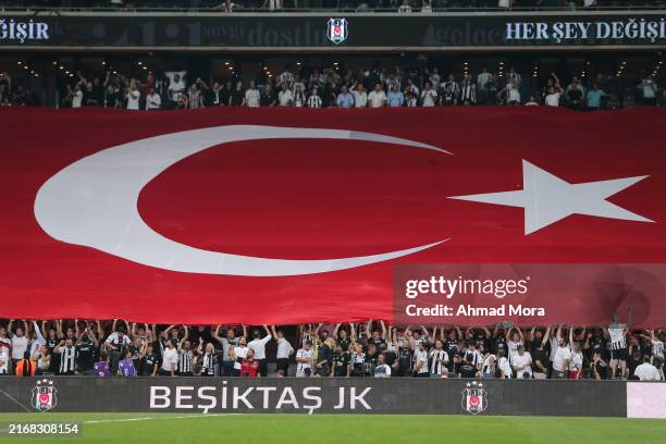 Besiktas fans hold Turkey's flag during the UEFA Europa League match between Besiktas and Lugano at Turpas Stadium on August 29, 2024 in Istanbul,...