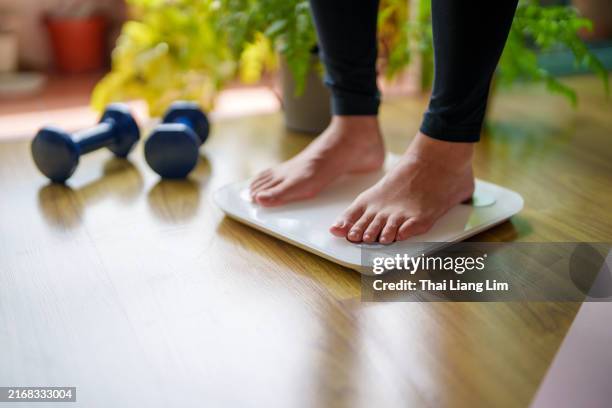 vue rapprochée d’une jeune femme debout sur une balance - balance photos et images de collection