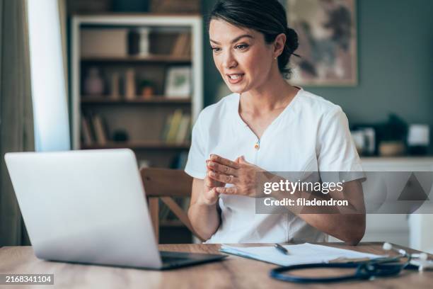 arzt spricht mit patient über laptop online - telemedizin stock-fotos und bilder