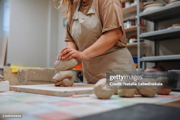 plus-size woman with dreads kneading clay in her pottery workshop, hands moving skillfully through the material. - gluten free foto e immagini stock