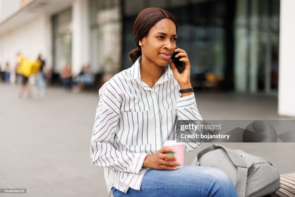 Young woman using phone in front of shopping mall