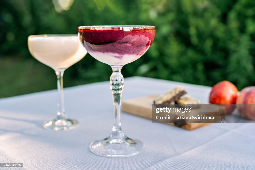 Cocktail glasses with fruit smoothie mocktail on a garden table