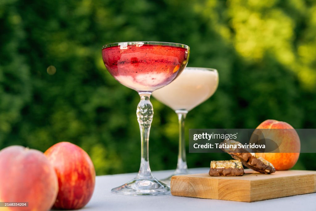 Cocktail glasses with fruit smoothie mocktail on a garden table