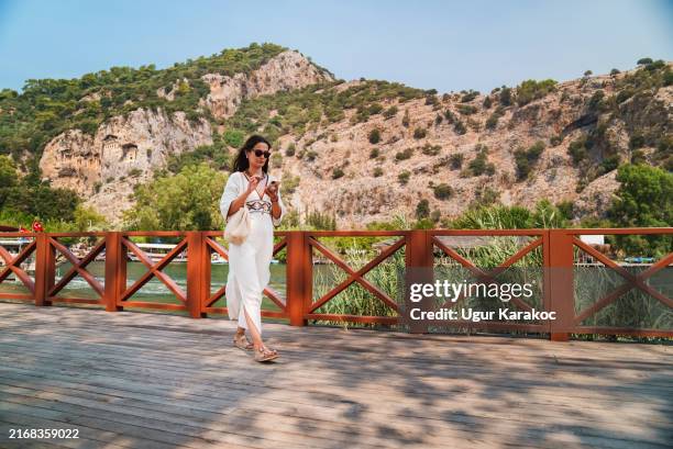 tourist woman using mobile phone while exploring the town. - quayside stock pictures, royalty-free photos & images