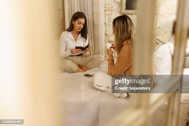female friends enjoying card game in cozy room in the evening - college student in suit stock pictures, royalty-free photos & images