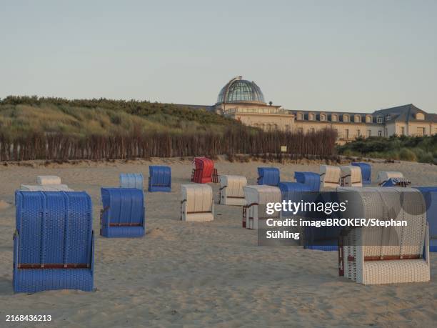 beach chairs on the sandy beach in front of a historic building in the dunes at dusk, juist, north sea, germany - ostfriesland stock-fotos und bilder