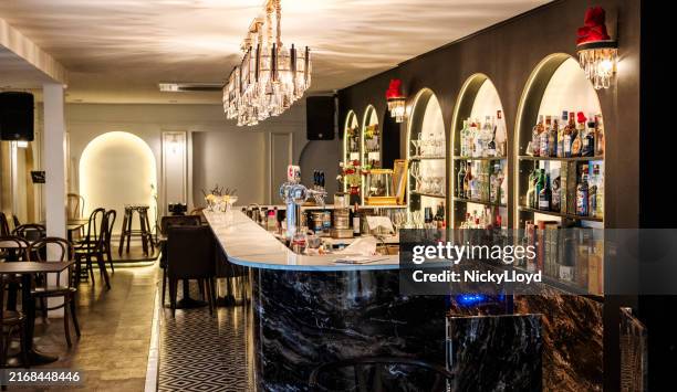 restaurant bar counter with alcohol bottles and empty seating area - vintage restaurant interior stock pictures, royalty-free photos & images