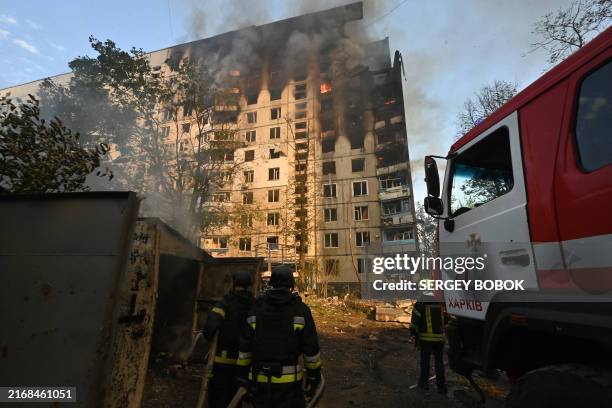 Ukrainian rescuers work to extinguish a fire in a residential building following a missile attack in Kharkiv on August 30, 2024. Russian strikes...