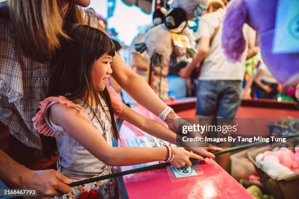 daughter and mother enjoying carnival game at street fair - fairground stall stock pictures, royalty-free photos & images