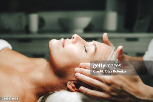 anti aging facial care: calm woman lying down for facial cleansing and treatment in spa clinic - máscara facial imagens e fotografias de stock