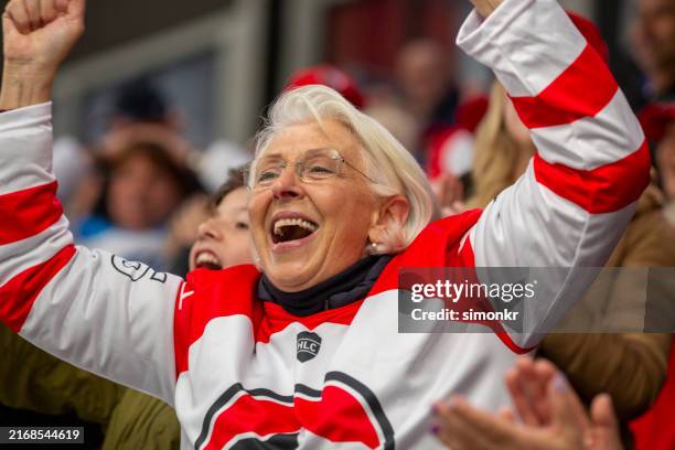 ekstatischer älterer fan jubelt vor freude - sporttrikot stock-fotos und bilder