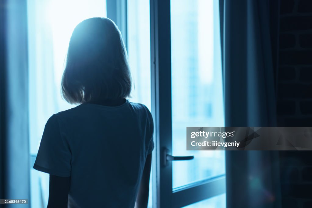 Frauensilhouette vor dem Fenster.