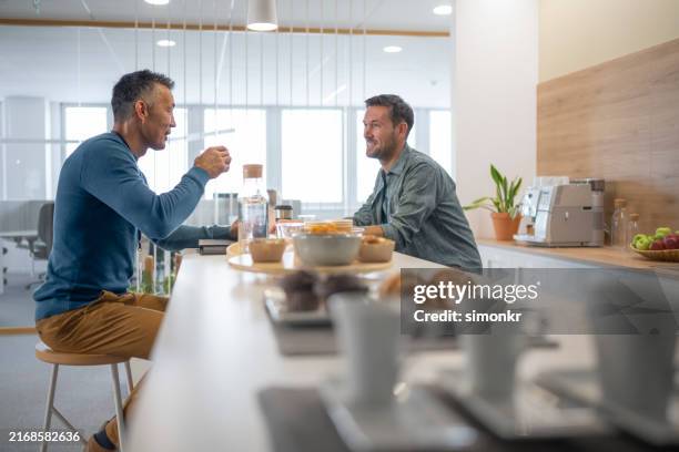 businessmen talking in modern office canteen - cantina imagens e fotografias de stock