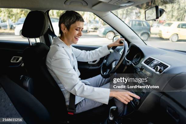 mujer madura subiendo el volumen de la radio del coche - equipo de alta fidelidad fotografías e imágenes de stock