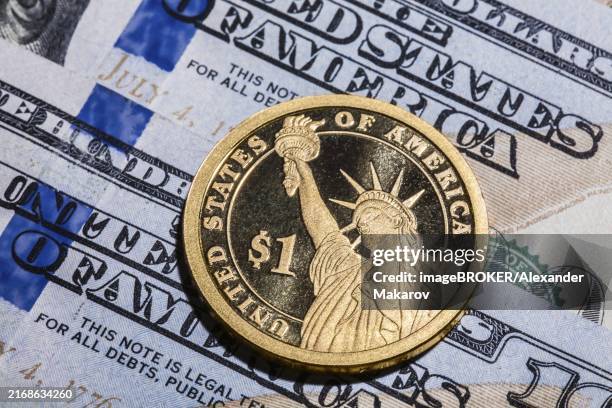 one dollar coin, the statue of liberty, on hundred dollars bills. closeup, macro shot - statue of liberty coin stock pictures, royalty-free photos & images