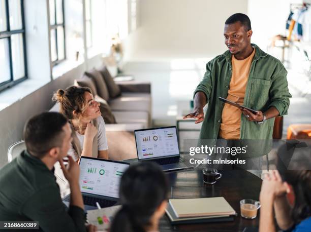 young professionals collaborating in a modern office environment - eficiência imagens e fotografias de stock