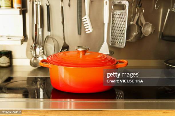 red cast iron pan on kitchen stove - cast iron stock pictures, royalty-free photos & images