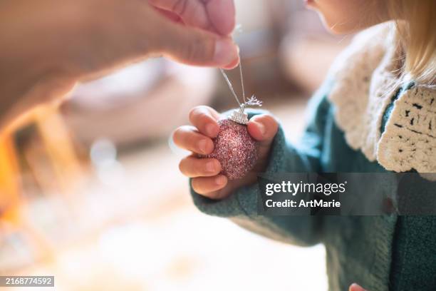 family decorating christmas tree - decorating the christmas tree stock pictures, royalty-free photos & images