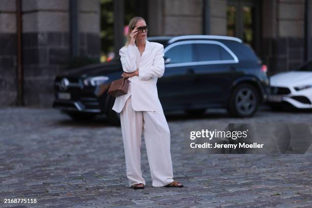 Mirja Klein seen wearing Tom Ford black / brown sunglasses, white cotton tank top, The Frankie Shop white oversized suit blazer jacket, matching The...