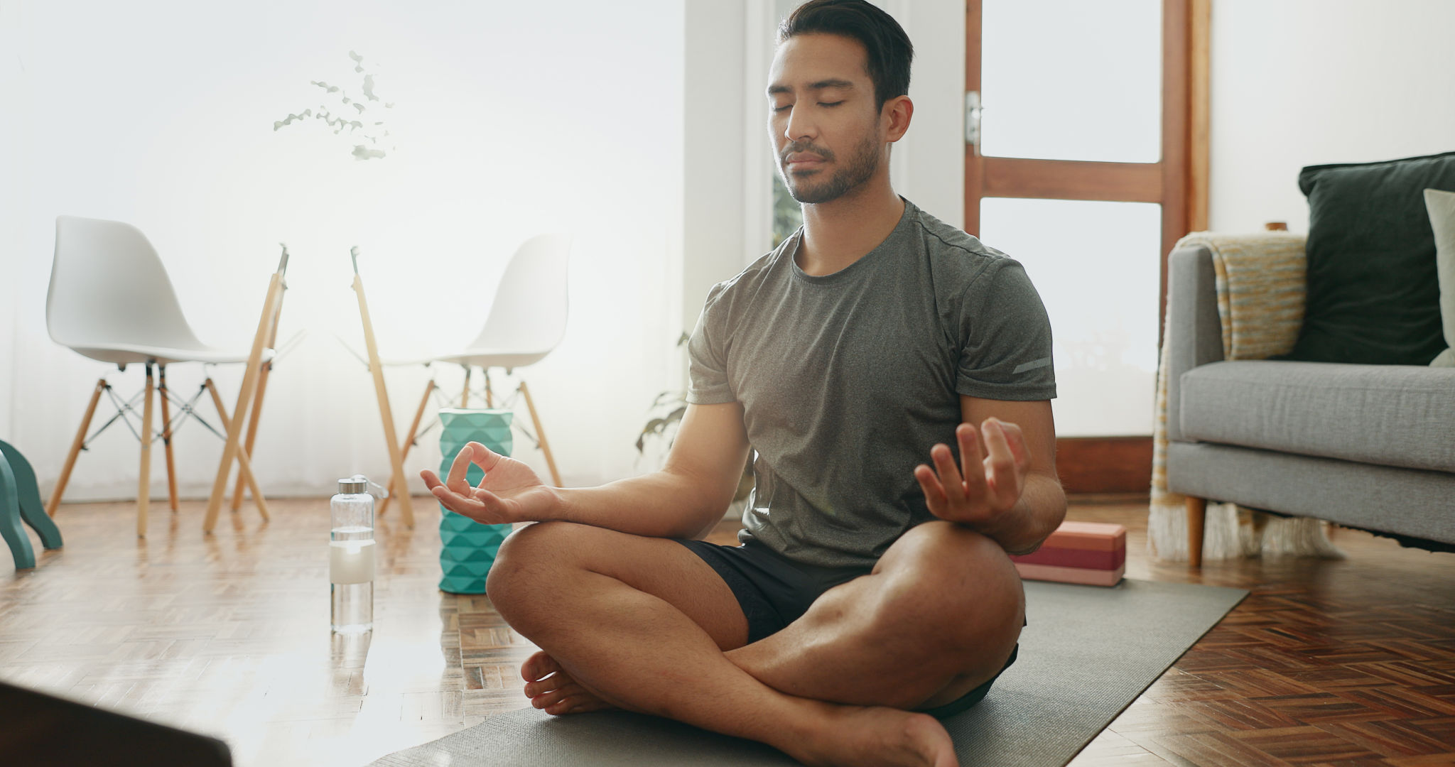 Laptop, pilates and man with meditation in house living room for yoga training, online class or breathing. Lotus, zen person and calm yogi relax for mental health, chakra balance or internet guide Laptop, pilates and man with meditation in house living room for yoga training, online class or breathing. Lotus, zen person and calm yogi relax for mental health, chakra balance or internet guide