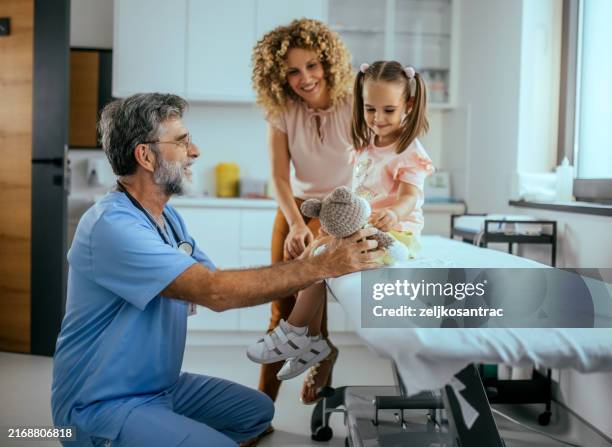 un pédiatre examine une petite fille dans son cabinet - pédiatre photos et images de collection