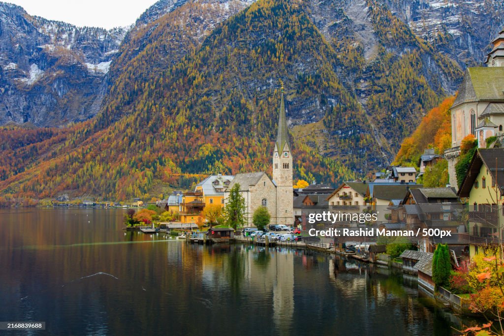 Scenic view of lake by buildings against mountain