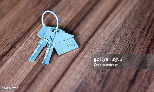 gros plan des clés de la maison sur une table en bois - clé de maison photos et images de collection