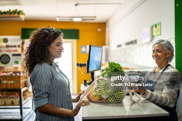 young customer woman buying vegetables at store - greengrocer stock pictures, royalty-free photos & images