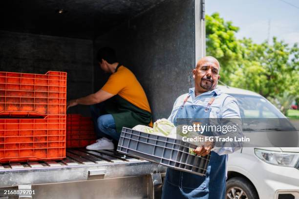 senior man unloading truck to store - greengrocers shop stock pictures, royalty-free photos & images
