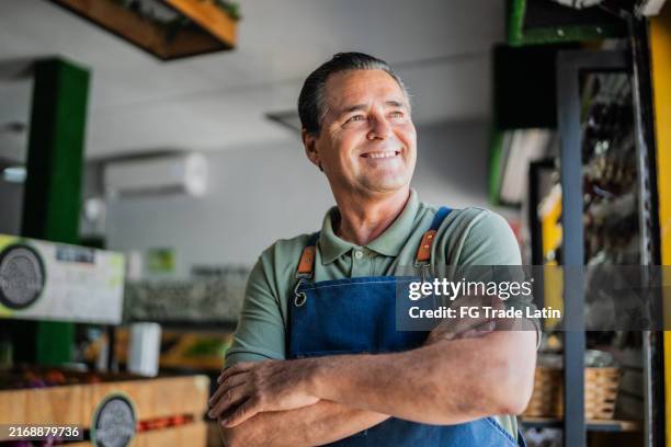 älterer mann, der im laden arbeitet und nachdenkt - small business owner stock-fotos und bilder