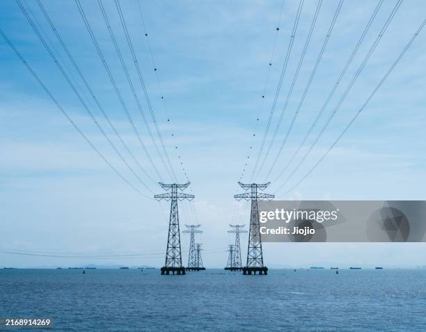 electricity pylon in the sea - funkwelle stock-fotos und bilder