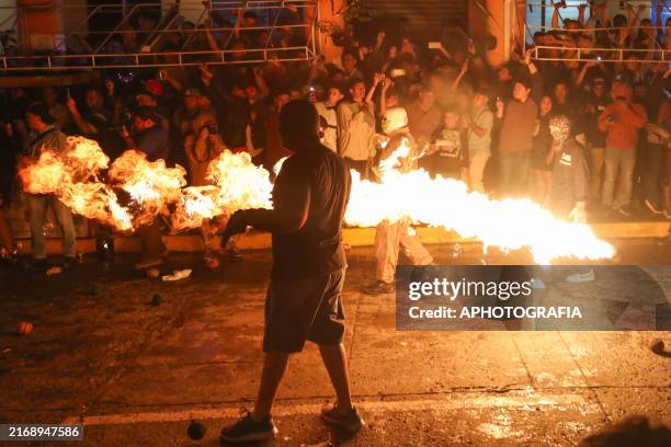 Young competitor with an outfit, gloves and mask throws a fireball during the celebration of the 102 years of "La Recuerda" with the tradition of...