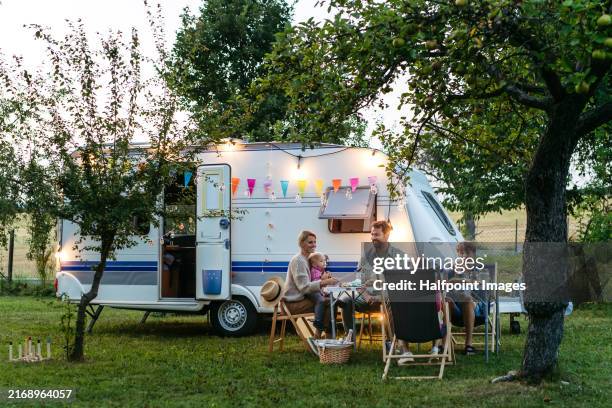 family traveling in caravan, having picnic diner. parents with three kids during camping trip. - camper trailer stock pictures, royalty-free photos & images