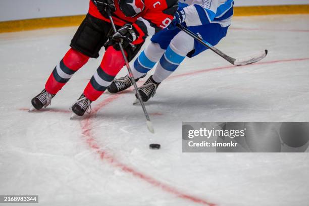 intensiver eishockeykampf um den puck - eishockey schläger stock-fotos und bilder