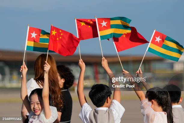 Chinese dancers hold national flags as they prepare for the arrival of Togo's President Faure Gnassingbe at the Beijing International Airport, ahead...