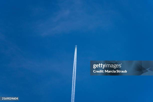 airplane streaking across clear blue sky - vapour trail stock pictures, royalty-free photos & images