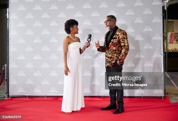 celebrity giving interview to media host at event - fotografia promocional imagens e fotografias de stock