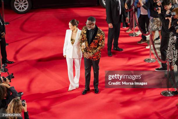 actors standing on red carpet - rode jurk stockfoto's en -beelden