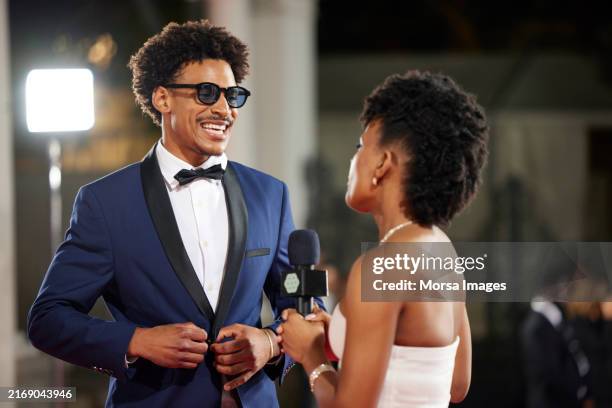 happy male celebrity talking with interviewer - music awards red carpet stock pictures, royalty-free photos & images