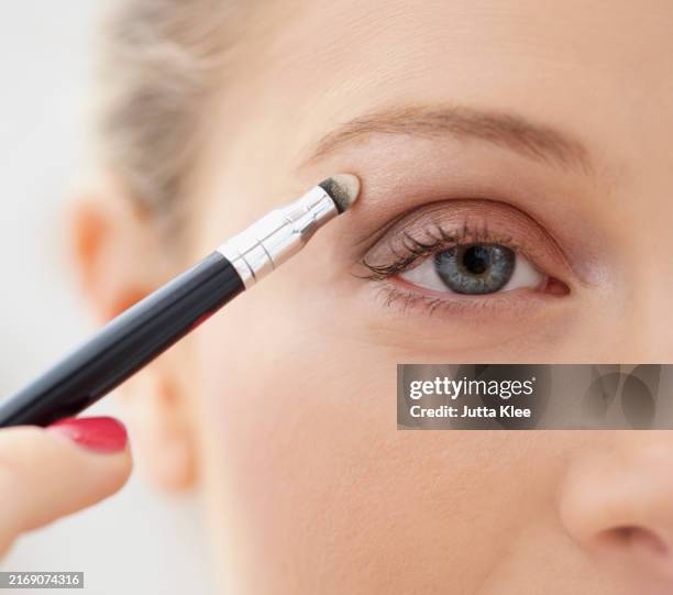 close-up view of woman applying eye shadow - eye make up stock pictures, royalty-free photos & images